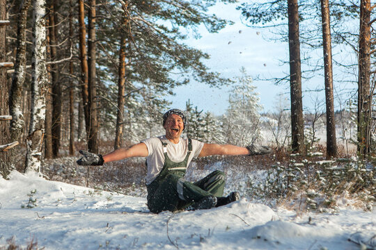An athletic man having winter fun with clean snow in the woods. Brutal man hardens to increase immunity. Nature power antistress winter concept