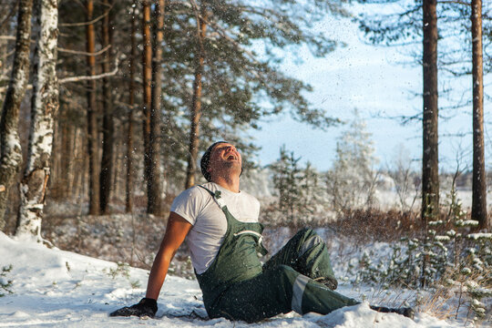 An athletic man having winter fun with clean snow in the woods. Brutal man hardens to increase immunity. Nature power antistress winter concept