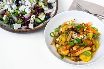 Greek salad in first plate, fried vegetable on second plate.