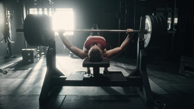 White Woman Doing Extreme Workout in a Hardcore Gym Using Barbell. Portrait of a Professional Powerlifter Determined to Improve Her Training and Exercising Endurance. Slow Motion Shot