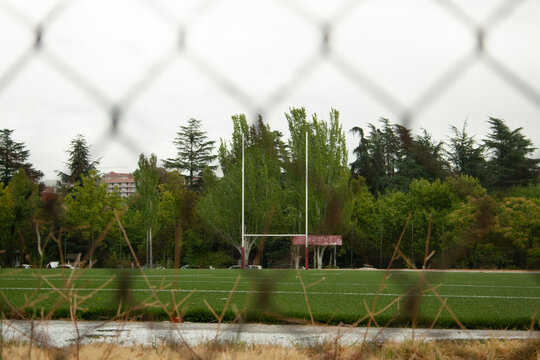 rugby field with the goal in the background and the image shot from behind a fence