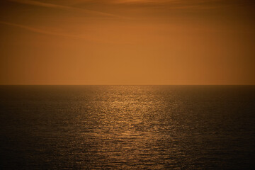 A photograph of a moody dark orange and brown sea view