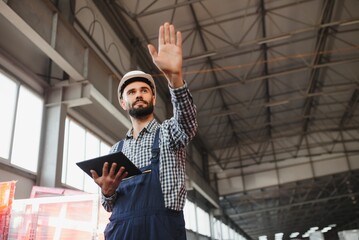 Factory technician working using digital tablet at factory warehouse