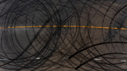Top view tire tracks texture and background. Asphalt texture with line and tire marks. Automobile automotive tire skid mark on race track. Abstract texture car drift tire skid mark.
