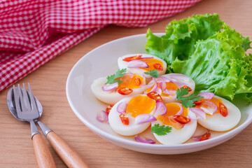 Spicy boiled eggs salad on white plate