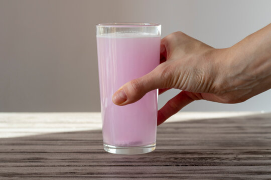 Electrolyte tablet is dissolved in water. Female hand holds a glass of rosewater. Oral rehydration salts for athletes.