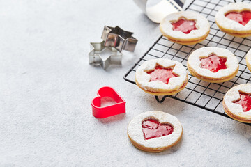 Classic Linzer Christmas Cookies with raspberry or strawberry jam on light background.
