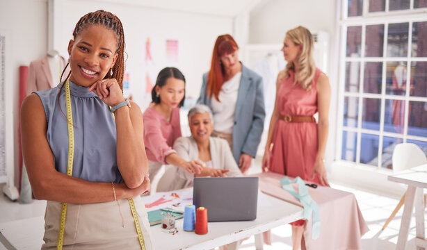 Portrait, designer and fashion with a black woman seamstress standing in her workshop with a team. Fabric, creative and tailor with a female design creative in a studio with a tape measure