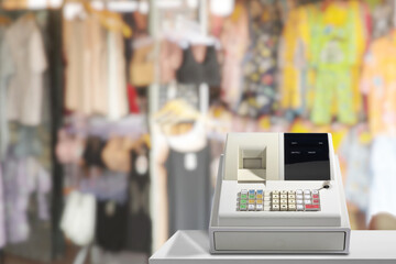 Electronic cash register has backdrop of a clothing store. - obrazy, fototapety, plakaty