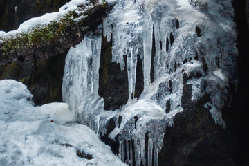 Obraz na płótnie Canvas Frozen icicles on rock