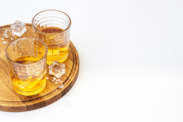 Glass of strong alcoholic drink whiskey with ice. Alcohol background