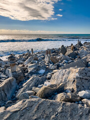 Ocean water splash on rock beach with beautiful sunset sky and clouds.  Sea wave splashing on stone at sea shore