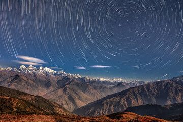 Panoramic night star trails view of Himalaya Mountain Range viewed from Lantang region of Nepal covered with snow and clouds and hills starry blue night abstract background. Starry night nature - 548228643
