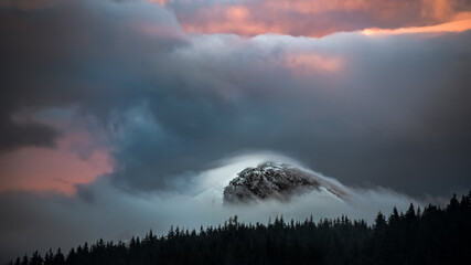 Dramatic Stormy Clouds over the Snowy Mountains of Hoverla snow covered peak in Ukraine. Dramatic light nature forest silhouette background. Hoverla is the higest Ukrainiam mountain. Famous symbol - 548228843
