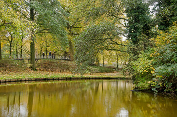 Rotterdam, The Netherlands, November 19, 2022: autumn reflections in the "romantic garden" in Museum Park, crossed by a pedestrian bridge