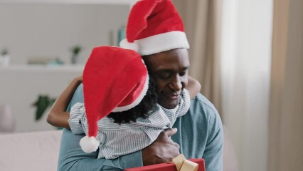 Close-up happy father hugging cuddling child holding new year box celebrating christmas enjoying holiday with family loving dad wear santa hat embracing little cute daughter kid girl rejoices at gift