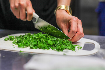 chef preparing food, cutting parsley