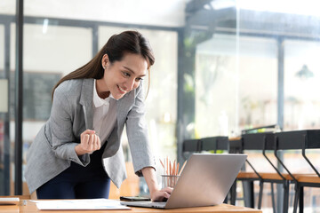 Excited happy Asian woman looking at the phone screen, celebrating an online win, overjoyed young asian female screaming with joy, isolated over a white blur background