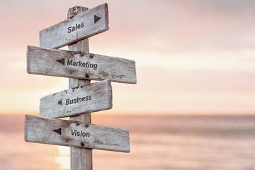sales marketing business vision text written on wooden signpost outdoors at the beach during sunset