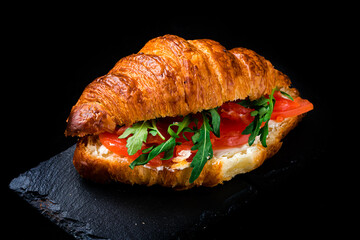 Croissant with salmon, tomato, cream cheese and arugula. - 548232463