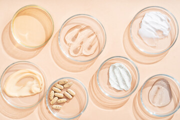 Fototapeta premium Natural medicine glass labware, petri dishes, cream jars, scrub, aromatic oils. Natural cosmetic background, healthy lifestyle.