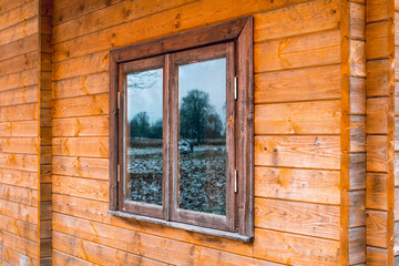 Perspective view to window of wooden house
