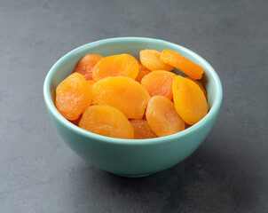 Dried apricots on a bowl over stone background