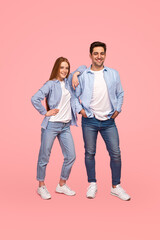 Fototapeta premium Cheerful young couple in similar clothes