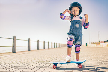 Children, skate and strong with a girl on her skateboard for fun on the beach promenade alone...