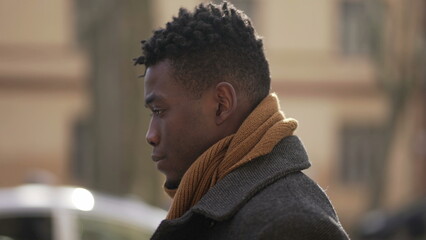 Pensive thoughtful black African man walking outside in winter season