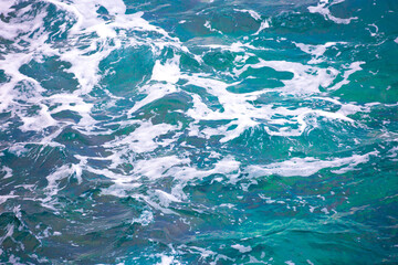 Fototapeta na wymiar Water background, turquoise shallow sea water. Beautiful texture of sun glare on the water. sea foam