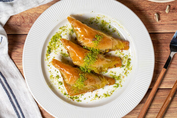 Sobiyet baklava with pistachio on wooden background. Turkish cuisine delicacies. Turkish baklava. Top view