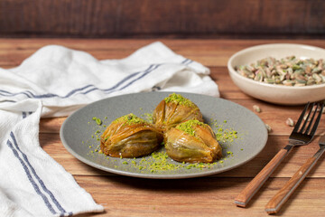 Mussel baklava with pistachio on wooden background. Turkish cuisine delicacies. Turkish baklava. close up