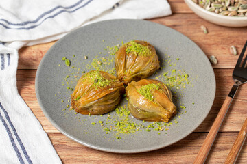 Mussel baklava with pistachio on wooden background. Turkish cuisine delicacies. Turkish baklava. close up