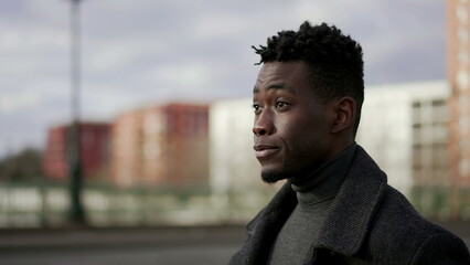 Pensive elegant black African man walking outside in city thinking about life