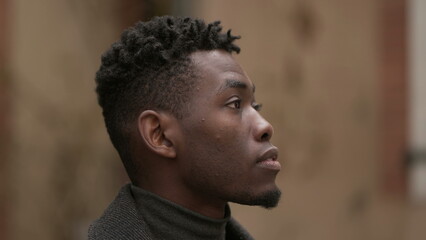 Pensive young black man standing in thought