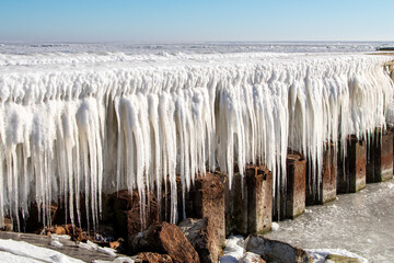 Ice sculptures and frozen water on the pier and dam of the Afsluitdijk, the giant dike of The...