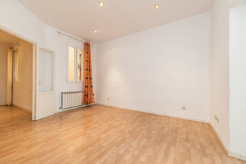 Residential house with light wooden floors, access to several rooms and orange curtains on the windows