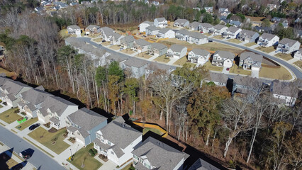 Suburban subdivision sprawl with row of high density brand new two story houses along park with...