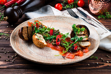 Salmon carpaccio with olive tapenade, hot peppers, herbs and croutons.