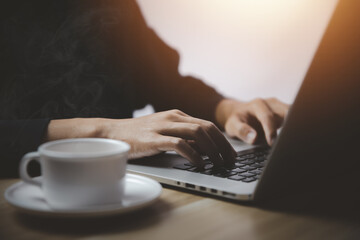 Businessman working in front of a laptop With a cup of hot coffee that has smoke and steam

