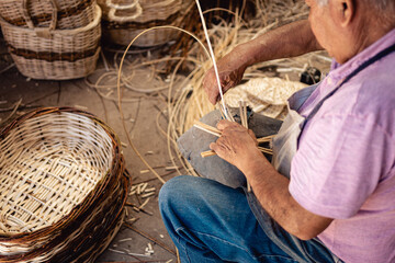 South American old man weaving wicker basket at his workshop. close up and High Angle top view.
