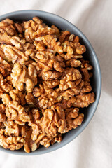 Raw Organic Walnuts in a Bowl, top view. Flat lay, overhead, from above.