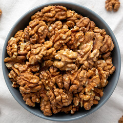 Raw Organic Walnuts in a Bowl, top view. Flat lay, overhead, from above. Close-up.
