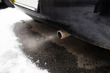 Fototapeta na wymiar pollution from car exhaust in the city in winter. Smoke from cars on a cold winter day