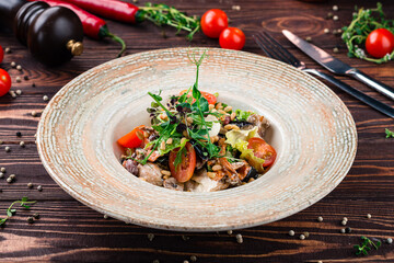 Salad with fried mushrooms, eggplant, chicken meat, cherry tomatoes, lettuce, greens, spices and...