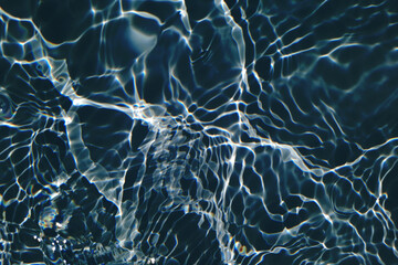 Defocus blurred transparent blue colored clear calm water surface texture with splashes and bubbles. Trendy abstract nature background. Water waves in sunlight with copy space. Blue watercolor shining
