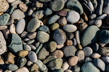 background of decorative polished river stones, Pale of stone. Stone path background above. The stones are small