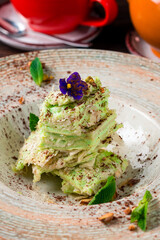 Dessert cake Napoleon or Millefeuille from puff pastry with custard pistachio cream.