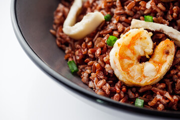 delicious red rice with shrimps and seafood on a white background